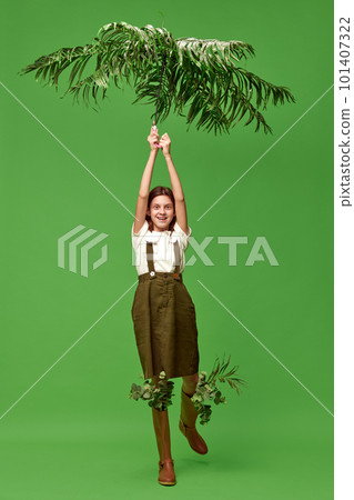 One adorable little girl wearing rain boots trying to fly by umbrella over green background. Mary Poppins One adorable little girl wearing rain boots trying to fly by umbrella over green background. Mary Poppins 101407322