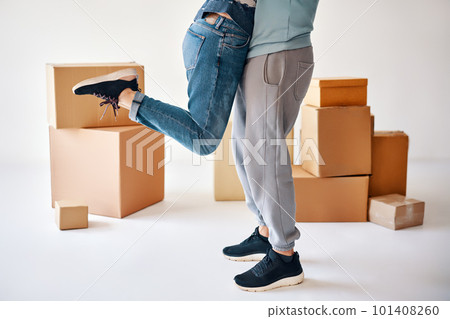 Husband lift wife surrounded by cardboard boxes excited to move in new flat, happy couple have fun hugging and celebrating 101408260
