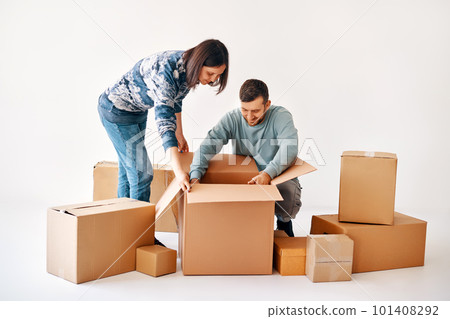 Happy couple unpacking boxes in new apartment at moving day 101408292