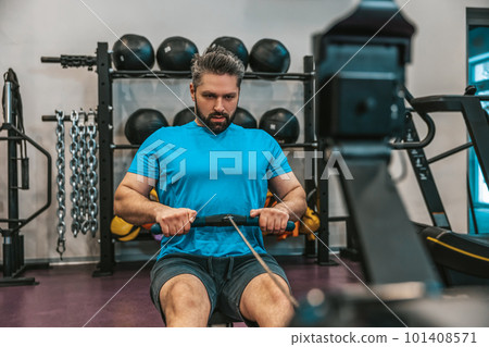 Sportsperson in a gym pulling weights and working on core 101408571