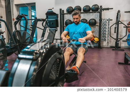 Sportsperson in a gym pulling weights and working on core 101408579