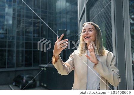 Cute blonde elegant woman having a video call Cute blonde elegant woman having a video call 101408669