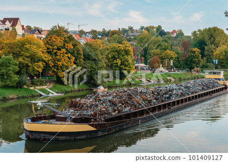 Transportation industry. Ship barge transports scrap metal and sand with gravel. Barge loaded with scrap metal is on the roadstead. Scrap metal transportation by water. Barge laden by metal salvage Transportation industry. Ship barge transports scrap metal and sand with gravel. Barge loaded with scrap metal is on the roadstead. Scrap metal transportation by water. Barge laden by metal salvage 101409127