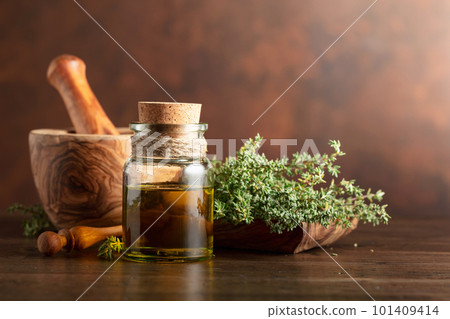 Bottle of thyme essential oil with fresh thyme. 101409414