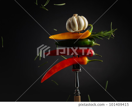 Red hot chili peppers with garlic and rosemary on a fork. 101409415