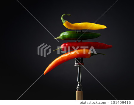 Colorful hot chili peppers on a black background. 101409416