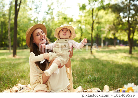 Happy harmonious family outdoors dressed in cool hats. mother with her baby have fan. summer evening 101409559