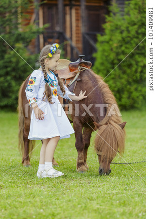 young girl in Ukrainian national dress strokes a pony young girl in Ukrainian national dress strokes a pony 101409981