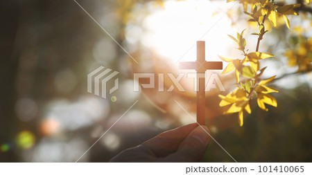 On a warm spring day with strong sunlight, he is holding yellow forsythia flowers and buds and the Holy Cross of Jesus Christ in his hand. 101410065