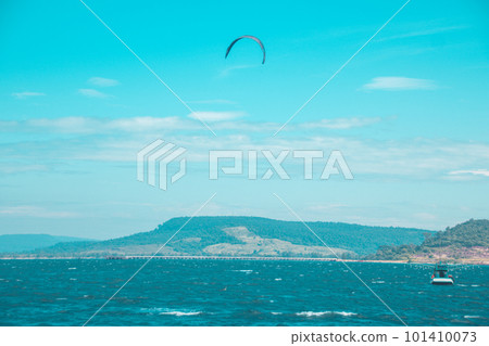 Kitesurfing parachute seen in the horizon of the blue sea and sky in a dreamy summer scene 101410073