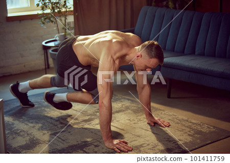 Cardio exercises. Sportive young man with relief, strong, muscular body training shirtless at home on daytime, running in plank Cardio exercises. Sportive young man with relief, strong, muscular body training shirtless at home on daytime, running in plank 101411759