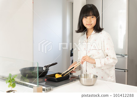 Girl in pajamas cooking in the kitchen Girl in pajamas cooking in the kitchen 101412288