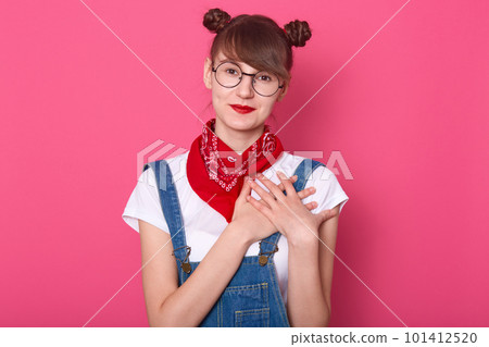 Close up portrait of lovely cheerful female with pleasant smile and friendly look, keep hands on chest, expresseing positive attitude, feeling gratitude to somebody, isolated over pink background. Close up portrait of lovely cheerful female with pleasant smile and friendly look, keep hands on chest, expresseing positive attitude, feeling gratitude to somebody, isolated over pink background. 101412520