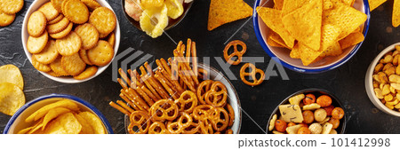 Salty snacks, party mix panorama. A variety of crispy appetizers, overhead 101412998