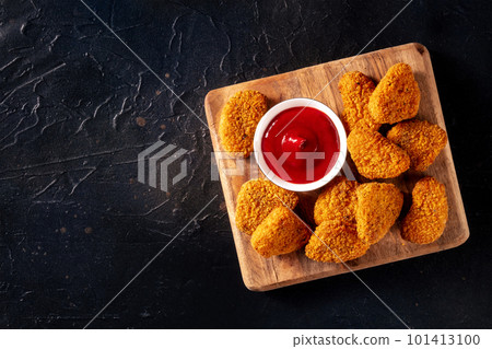 Chicken nuggets with bbq sauce on a black background, shot from above Chicken nuggets with bbq sauce on a black background, shot from above 101413100