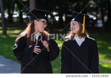 Two happy female students in prom dresses outdoors. 101413689