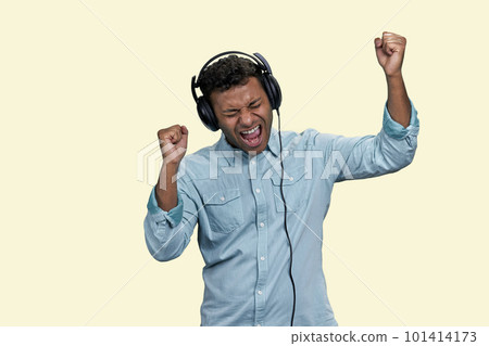 Portrait of Indian man listen to music in headphones and singing. Isolated on white background. 101414173