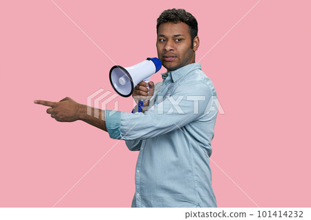Young indian businessman speaking in megaphone and pointing at something. Isolated on pink background. 101414232