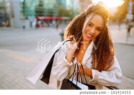 Young woman with shopping bags walking on street. , Sale concept. 101414353