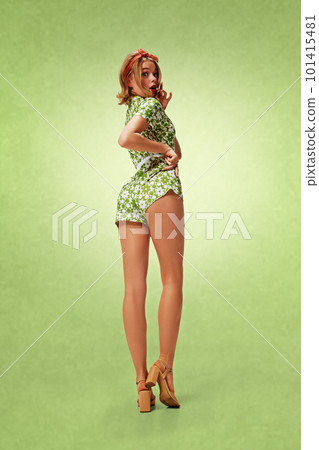 Full-length image of young pretty blonde girl in attractive costume posing with cute shocked face against green background. Pin-up style Full-length image of young pretty blonde girl in attractive costume posing with cute shocked face against green background. Pin-up style 101415481