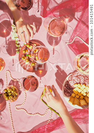 Vertical image of female hands over table with rose wine and appetizers, snacks on pink textured background, tablecloth Vertical image of female hands over table with rose wine and appetizers, snacks on pink textured background, tablecloth 101415491