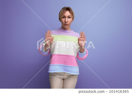 concentrated attentive blond young woman shows stop with hand on purple background 101416365
