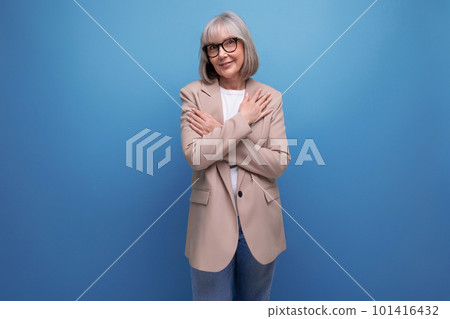 60s middle-aged woman in a stylish laconic jacket on a studio background with copy space 101416432