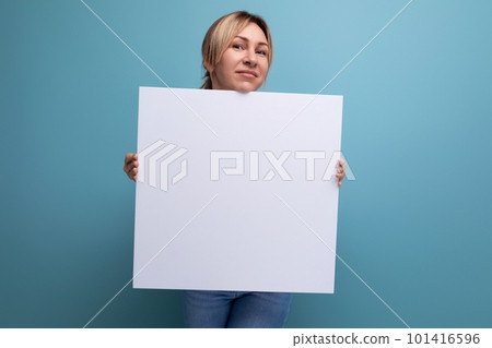 attractive blond woman holding a sheet of paper with a mocap for advertising on a purple background 101416596