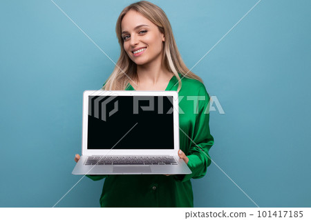 adorable girl holding a laptop with a screen to insert a website on a blue bright background 101417185