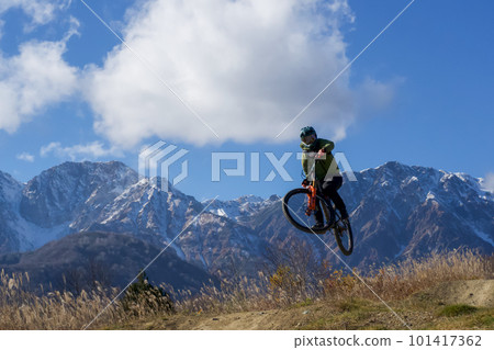 Mountain biker jumping on the back of the mountain Mountain biker jumping on the back of the mountain 101417362