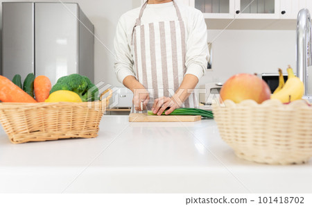 一個 40 多歲的男人在廚房里切菜 一個 40 多歲的男人在廚房里切菜 101418702