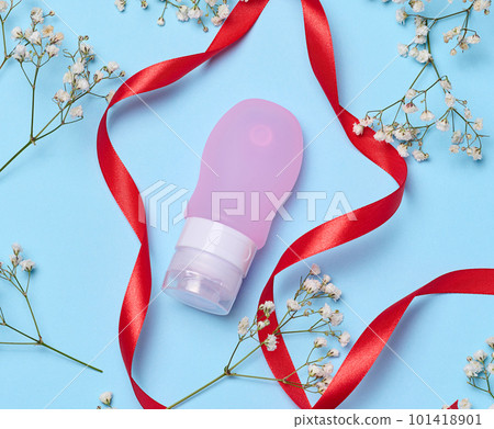 Pink plastic tube for cosmetics and sprigs of white gypsophila flowers, top view Pink plastic tube for cosmetics and sprigs of white gypsophila flowers, top view 101418901