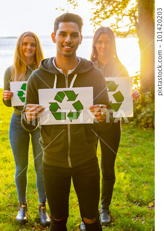 Group of volunteers holding recycling symbol placards 101420203