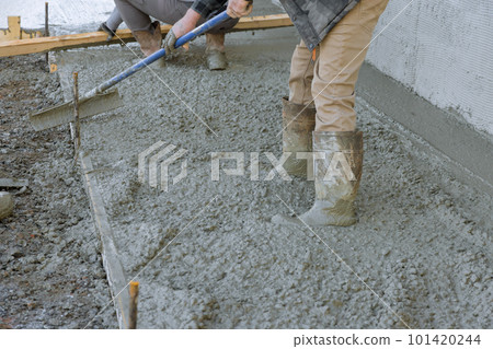 After pouring concrete employee used long trowels to level sidewalk. After pouring concrete employee used long trowels to level sidewalk. 101420244