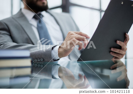 man working from home office doing notes sitting at desk 101421118