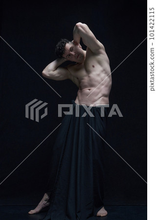 Full-length portrait of mature, muscular, handsome, shirtless man posing in dark fabric against black studio background 101422115