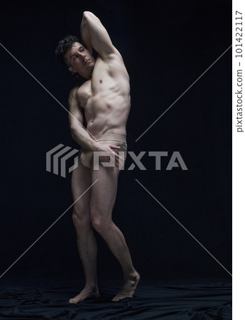 Full-length portrait of handsome, athletic man posing shirtless in underwear against black studio background Full-length portrait of handsome, athletic man posing shirtless in underwear against black studio background 101422117