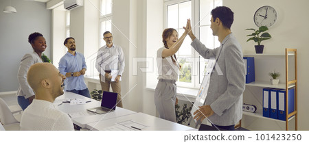 Joyful colleagues give each other high five in office after successfully completed work together. Joyful colleagues give each other high five in office after successfully completed work together. 101423250