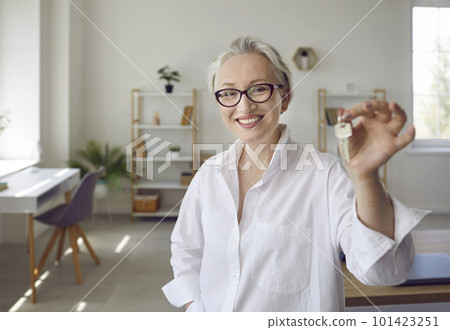 Portrait of happy mature woman holding keys to her newly bought house and smiling Portrait of happy mature woman holding keys to her newly bought house and smiling 101423251
