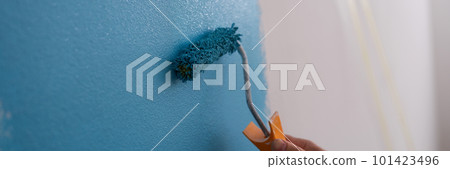 Male decorator painting wall in blue color 101423496