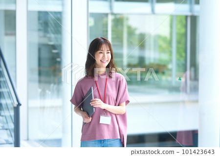 Young female engineer in casual outfit walking in office corridor 101423643
