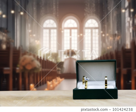 golden wedding rings with blurred traditional wedding chapel or church on background, wedding ceremony concept 101424238