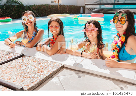 Group of friends in swimsuit drink a cocktail in a swimming pool 101425473