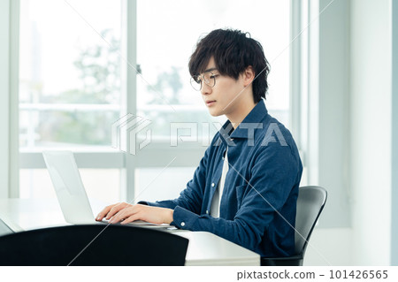 A young man who operates a computer A young man who operates a computer 101426565