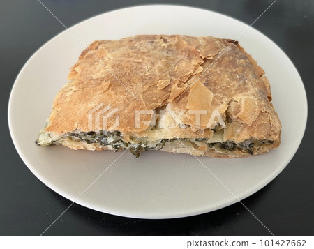 Spanakopita, a traditional Greek pie with spinach and feta wrapped in a thin phyllo dough Spanakopita, a traditional Greek pie with spinach and feta wrapped in a thin phyllo dough 101427662