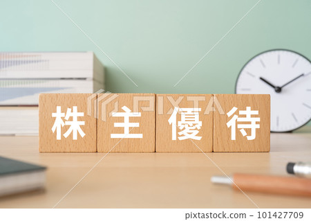 A desk with a block written as shareholder benefits 101427709