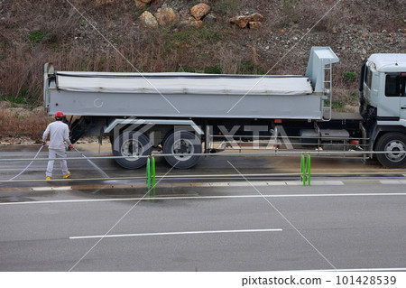 A worker removing mud from a dump truck A worker removing mud from a dump truck 101428539