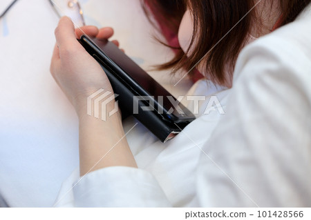 Woman looking at smartphone while lying in bed 101428566