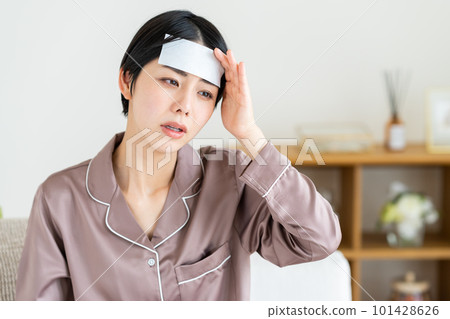 一個穿著睡衣發燒的年輕女人 一個穿著睡衣發燒的年輕女人 101428626