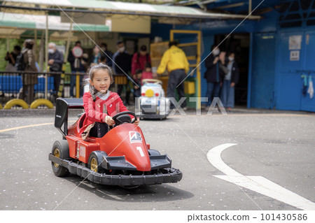 A 7-year-old girl who seems to be having fun riding an electric car A 7-year-old girl who seems to be having fun riding an electric car 101430586